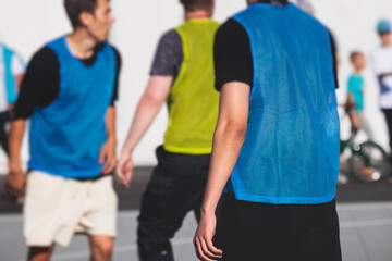 Fototapeta premium Athletes play basketball, teenage team play street basketball, players on the outdoor basketball court venue, sports team during the game, playing match game in a summer sunny day