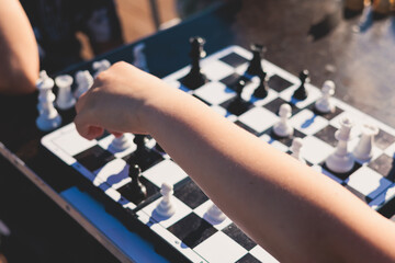 Chess tournament, kids and adults participate in chess match game outdoors in a summer sunny day,...