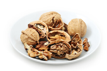 Walnuts on white plate, Walnuts kernels and shells