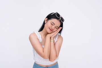A young asian woman making a napping gesture with eyes closed. Suggesting to have a short rest....