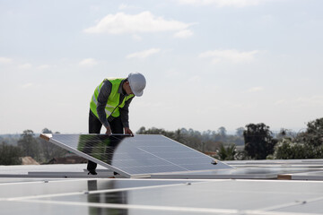 A technician installing the solar panels at roof top of home and home office ,concept of economic energy and cost saving ,own small business