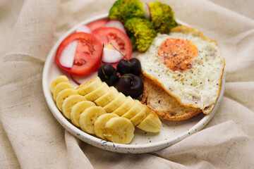 Breakfast, fried egg toast with vegetables and fruits.