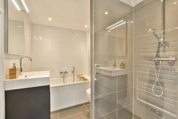 a modern bathroom with white tile and gray tiles on the walls, along with a walk - in shower stall
