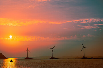 Wind turbines at sunset in the sea. Beautiful landscape of wind turbines at sunset.