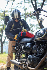 Young man pack his bag on his motorbike getting ready on adventure riding