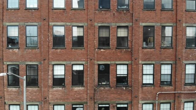Aerial shot of Brooklyn's Urban Landscape: Parallel Drone Flight Along Brick Building With Many Windows. Brooklyn, NYC, USA