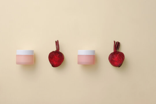 A line of beetroot and unlabeled cosmetic jar arranged on beige background. Beetroot (Beta vulgaris) is an excellent source of protein, iron and phosphorus
