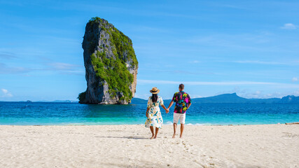 Koh Poda Krabi Thailand, an Asian woman and a European man walking on the tropical beach of Koh Poda Island Krabi Thailand. - obrazy, fototapety, plakaty