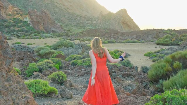 Pretty walk in red dress at Teide national park 