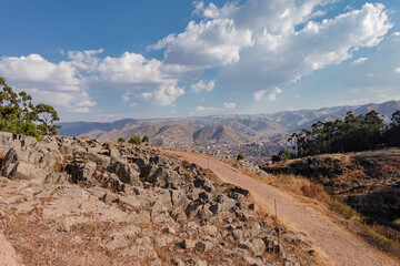 Vista desde la parte alta de la zona arqueológica de Qenko en Cusco, Perú, se aprecia la ciudad a lo lejos y muchas nubes
