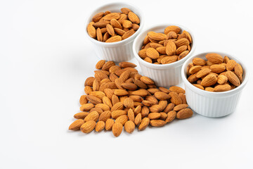 Three ceramic bowls with piles of almonds