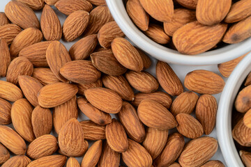 Close-up of a pile of almonds next to white containers