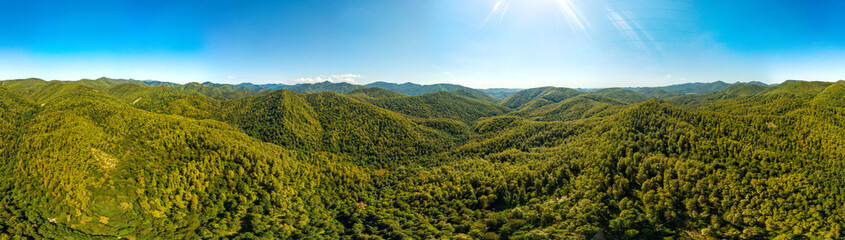 Naklejka premium wide aerial panorama overlooking the mountain gorges in the forested mountains of the western caucasus (southern Russia) on a sunny summer day