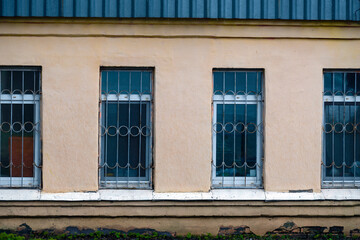 Iron bars on the windows of the building on an autumn day