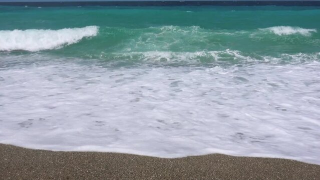 Tropical beach in the Philippines. Small waves crash onto the sand at Looc Fishing VIllage, Surigao Philippines.