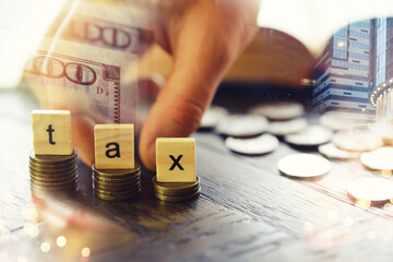 Tax wooden letter on wooden block.Pay tax .Income tax return. Double exposure city, dollar.