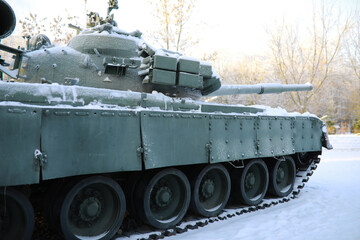 Fototapeta na wymiar Military tank in a row. Battle tank in the snow on the roadside of highway. War in Ukraine in winter.