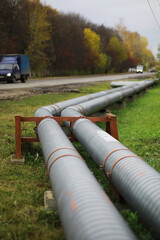 Metal pipes on the street. pipes from the pipeline. gas pipeline for gas pumping. heat-pipe. large silver colored pipe for hot water.