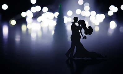 Black silhouettes of pair dancers performing. Man and woman are dancing with white backlight. Choreography. New Year's ball