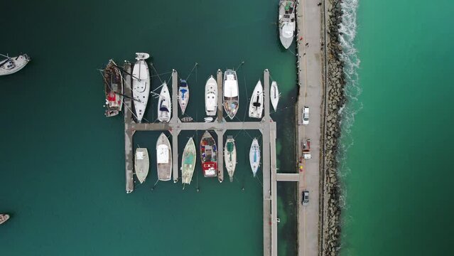 Aerial drone top down bird eye of Apollo Bay Harbour Marina Australia with boats moored at docks on calm blue turquoise water