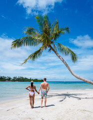Fototapeta na wymiar Tropical Island Koh Kood or Koh Kut Thailand. Couple men and women on vacation in Thailand walking at the beach with a hanging palm tree, holiday concept Island hopping in Eastern Thailand Trang