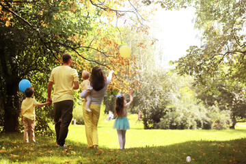 Fototapeta premium Family with children for a walk in the summer park. Сoming autumn&nbsp;in the park. Family. Fall. Happiness.