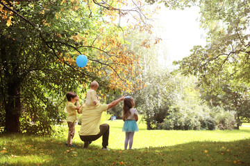 Family with children for a walk in the summer park. Сoming autumn in the park. Family. Fall. Happiness.