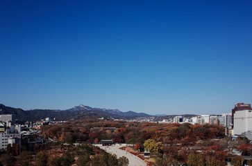 푸른 하늘이 펼쳐진 서울 옥상에서 본 가을 산과 문화 유산 풍경