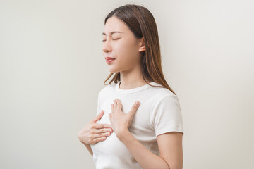 Obraz premium Acid reflux disease, suffer asian young woman have symptom gastroesophageal, esophageal, stomach ache and heartburn pain hand on chest from digestion problem after eat food, Healthcare medical concept
