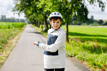 Active school boy skating in summer park, healthy lifestyle for children. Happy teenager with...