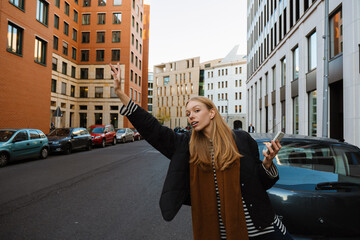 Young woman hailing taxi at city street © Drobot Dean
