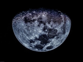 This close-up photo of the moon shows the craters and mountains on its surface in great detail. The moon is a beautiful and mysterious object, and this photo captures its beauty and complexity. The cr