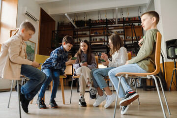 Group of kids playing educational card game while sitting in library