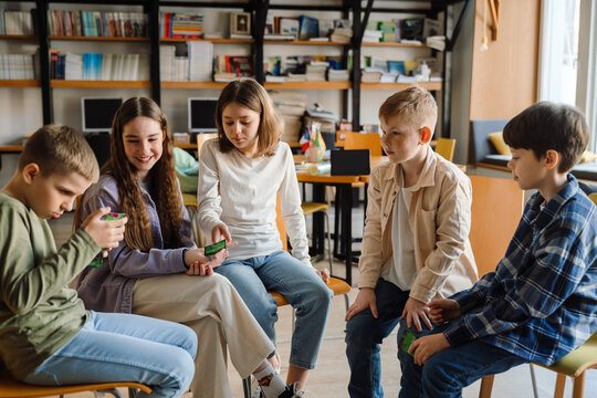 Group of kids playing educational card game while sitting in library
