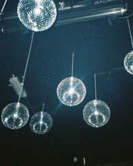Disco balls hanging from the ceiling in vibrant club scene
