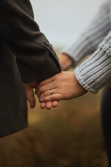 Engaged couple holding hands on a winter walk