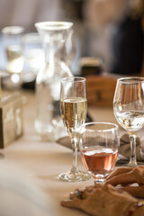 Champagne glass amidst lively tables at summer wedding