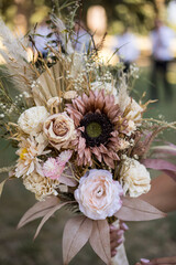 Bride holding a rustic dried flower wedding bouquet