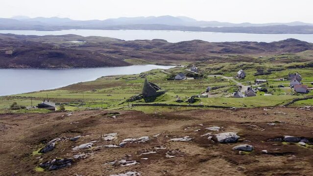 Wide angle drone shot of the 'Dun Carloway Broch' on the west coast of the Isle of Lewis, part of the Outer Hebrides of Scotland. The broch is a tourist attraction first built around 100AD.