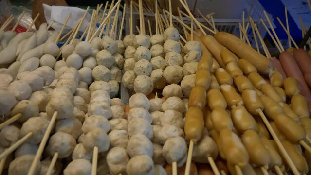 thailand night market street food booth beef pork fish meat balls sausages in bamboo sticks