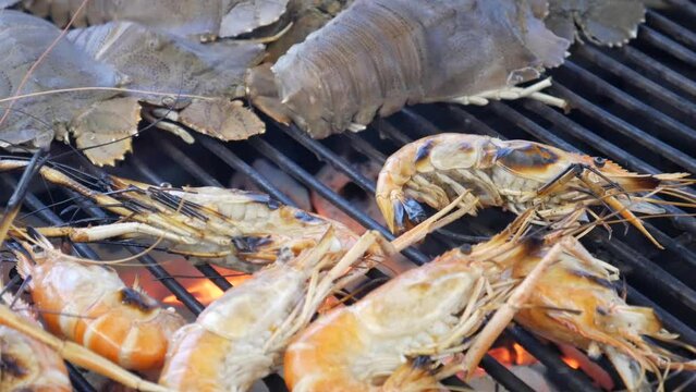 grill cooking slipper lobster and river prawns on hot charcoal in thailand seafood restaurant
