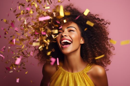 Fun party girl, smiling woman throwing confetti on a pastel pink background. Composition for birthday or woman's day. Party time concept.
