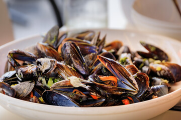 Freshly cooked mussels steamed in white wine sauce or moules marinieres on a plate at a restaurant...