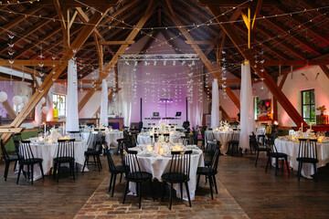 Beautiful table setting and decorations at a wedding. Wedding venue with beautiful decor, flowers, cutlery and lights