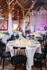 Beautiful table setting and decorations at a wedding. Wedding venue with beautiful decor, flowers, cutlery and lights