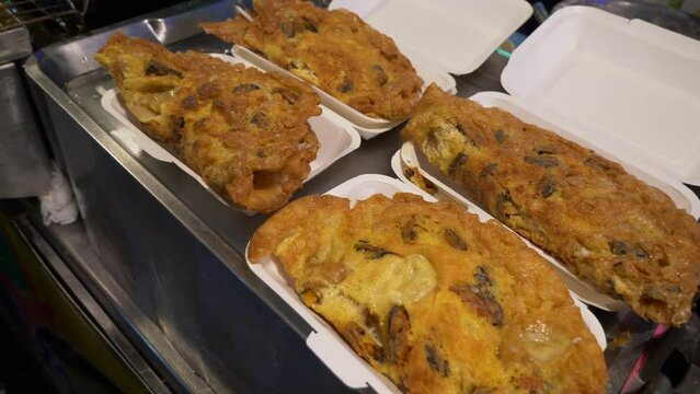 fried oyster pan cake omelette in thailand night market street food restaurant