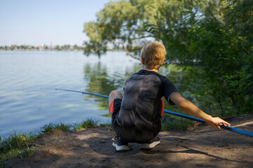 The boy prepared to hook the fish. Sport fishing on the river in summer.