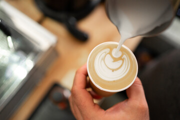 Barista make coffee latte art with coffee espresso machine in coffee shop cafe, top view. Morning aroma coffee lifestyle urban people concept.