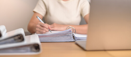 Asian woman working with computer laptop, female businesswoman reading report and sign contract with documents folder stack at home or office late night. Overworked, work hard and business concept