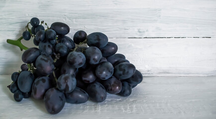 A bunch of large grapes on a wooden background. Big, dark grapes.